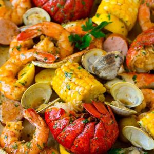 Seafood boil with lobster tail, shrimp, corn, sausage, and potatoes