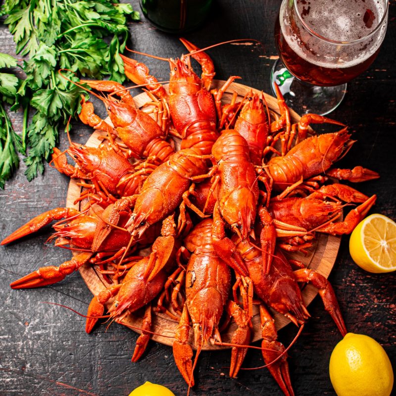 Boiled crayfish with a glass of beer and lemon.